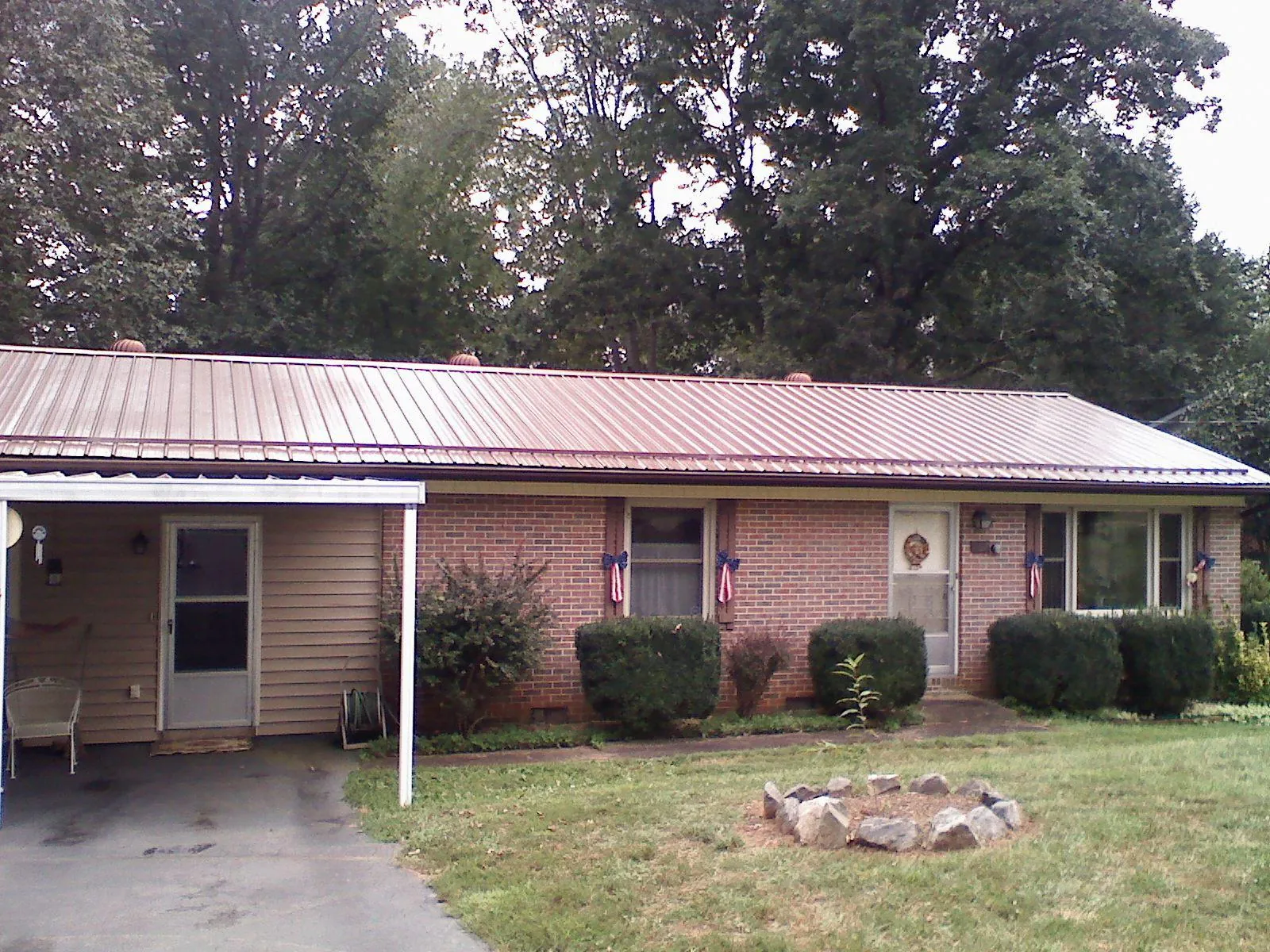 Bronze metal roof and carport on a brick ranch home — Roof Repair work by our crew in Winterville